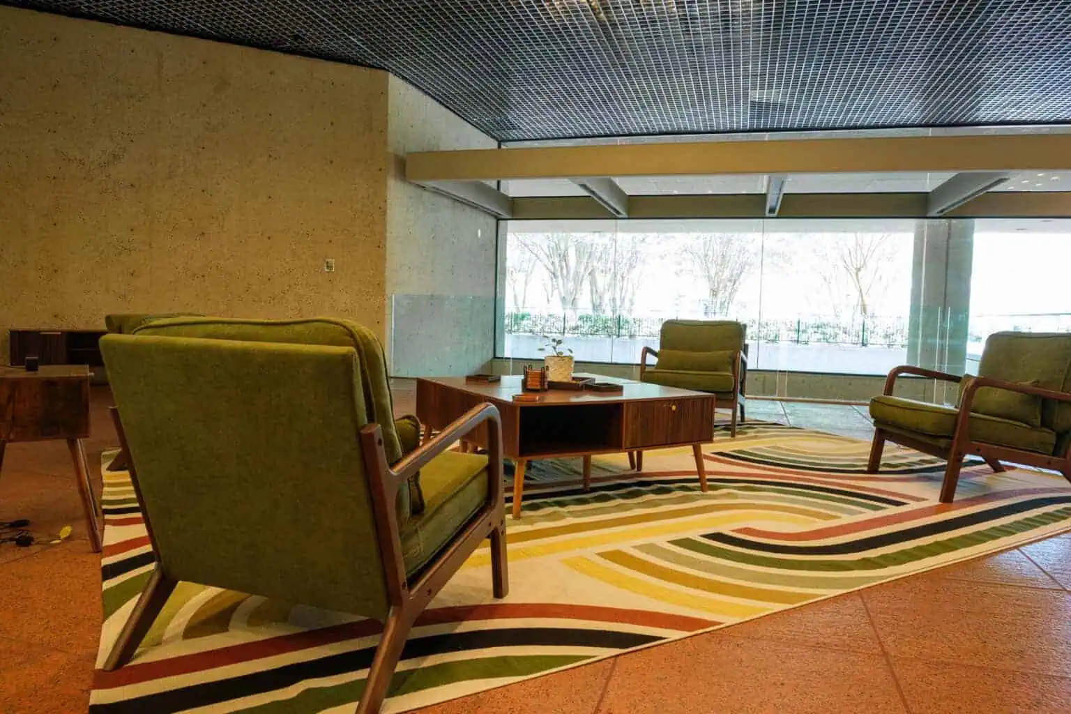 Shared lounge with seating beside the windows at Tributary