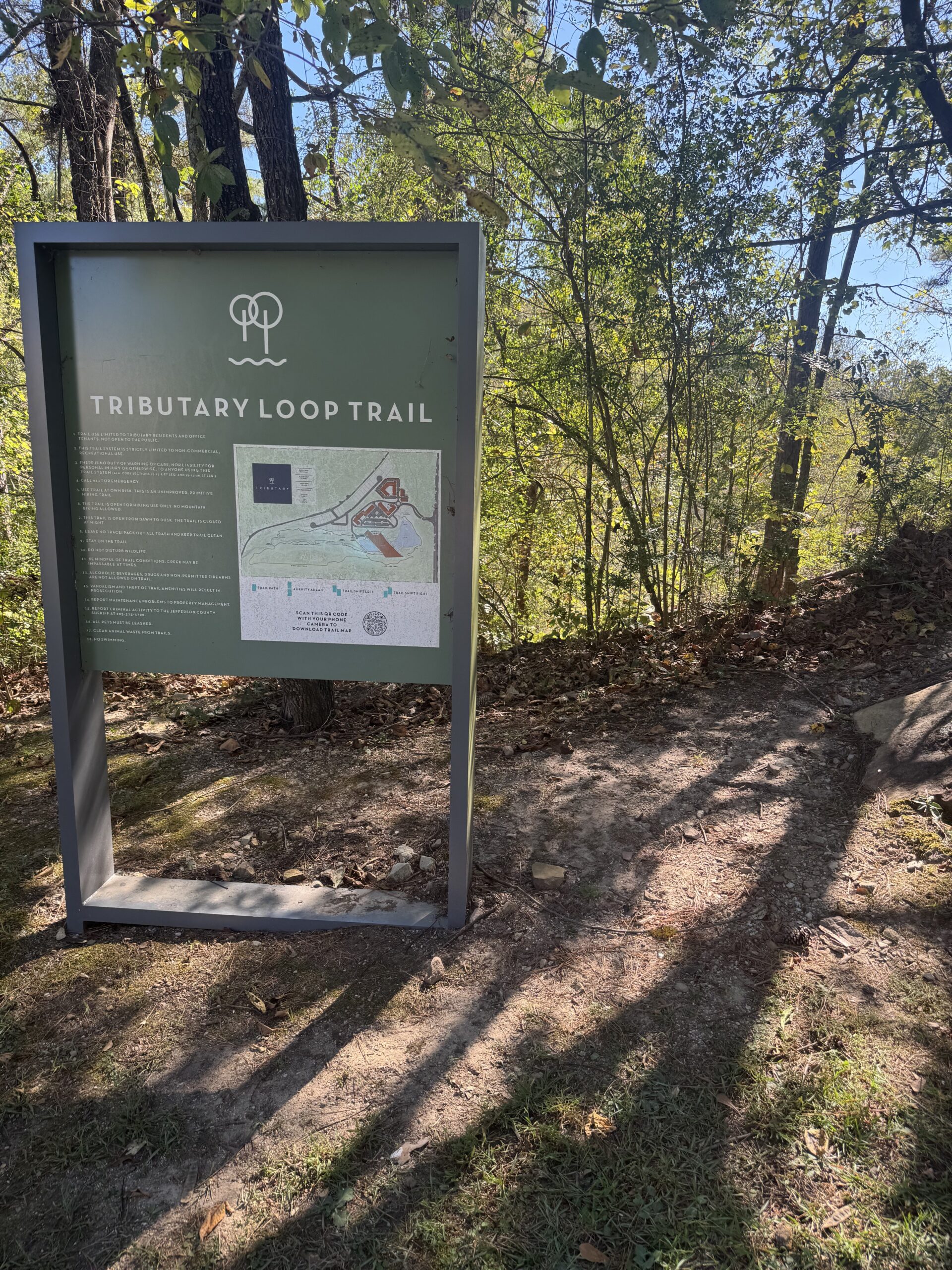 Tributary Loop Trail sign beside the wooded trail
